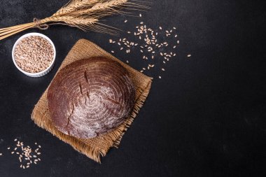 Esmer taze ekmek ve koyu beton arka planda tohumlar. Üst görünüm, alanı kopyala