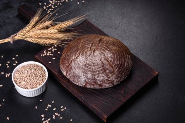 Esmer taze ekmek ve koyu beton arka planda tohumlar. Üst görünüm, alanı kopyala