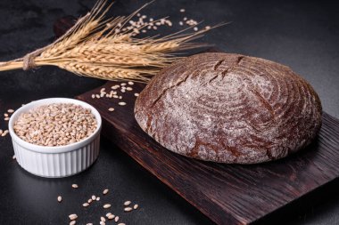 Esmer taze ekmek ve koyu beton arka planda tohumlar. Üst görünüm, alanı kopyala