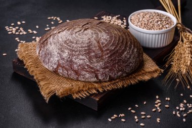 Esmer taze ekmek ve koyu beton arka planda tohumlar. Üst görünüm, alanı kopyala