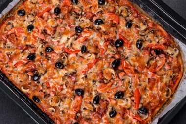 Küçük ev yapımı sebze pizzası. Yanında da domates, zeytin ve otlar.