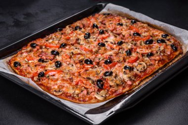 Küçük ev yapımı sebze pizzası. Yanında da domates, zeytin ve otlar.