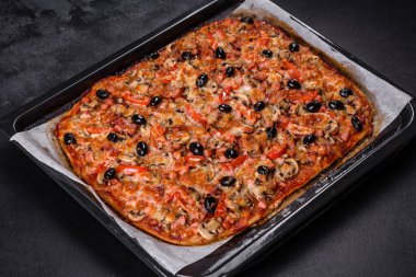 Küçük ev yapımı sebze pizzası. Yanında da domates, zeytin ve otlar.