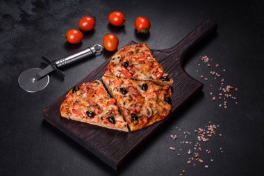Küçük ev yapımı sebze pizzası. Yanında da domates, zeytin ve otlar.