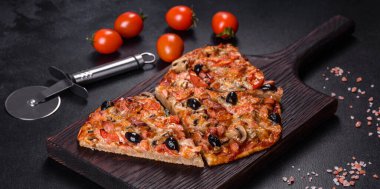 Küçük ev yapımı sebze pizzası. Yanında da domates, zeytin ve otlar.
