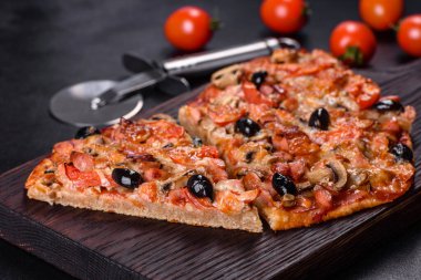 Küçük ev yapımı sebze pizzası. Yanında da domates, zeytin ve otlar.