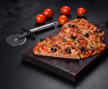 Küçük ev yapımı sebze pizzası. Yanında da domates, zeytin ve otlar.