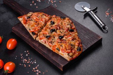 Küçük ev yapımı sebze pizzası. Yanında da domates, zeytin ve otlar.