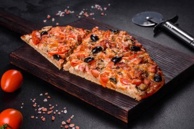 Küçük ev yapımı sebze pizzası. Yanında da domates, zeytin ve otlar.