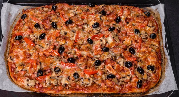 Küçük ev yapımı sebze pizzası. Yanında da domates, zeytin ve otlar.