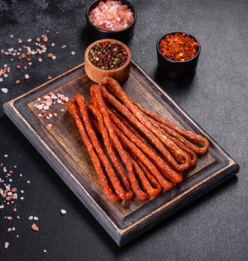 Lezzetli taze füme sıcak sosis ve koyu beton bir masada kiraz domatesleri.