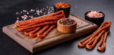 Lezzetli taze füme sıcak sosis ve koyu beton bir masada kiraz domatesleri.