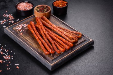 Lezzetli taze füme sıcak sosis ve koyu beton bir masada kiraz domatesleri.