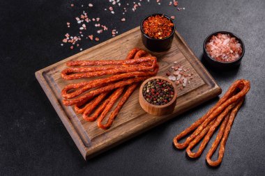 Lezzetli taze füme sıcak sosis ve koyu beton bir masada kiraz domatesleri.