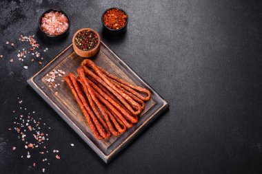 Lezzetli taze füme sıcak sosis ve koyu beton bir masada kiraz domatesleri.