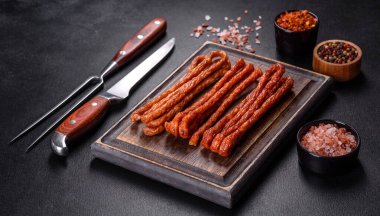 Lezzetli taze füme sıcak sosis ve koyu beton bir masada kiraz domatesleri.