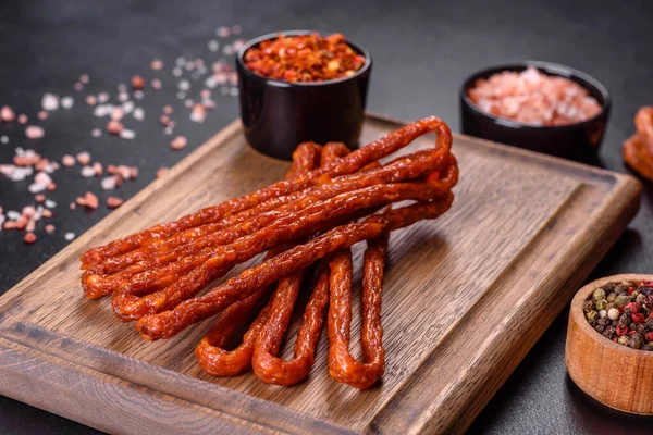 Lezzetli taze füme sıcak sosis ve koyu beton bir masada kiraz domatesleri.