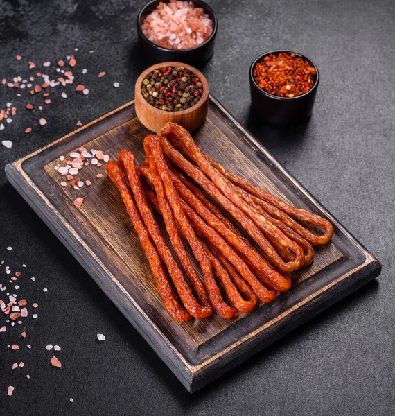 Lezzetli taze füme sıcak sosis ve koyu beton bir masada kiraz domatesleri.