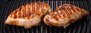 Lezzetli taze ızgara tavuk filetosu, esrarlı baharatlar ve çimento kaplı otlar. Ateşte pişirilmiş bir tabak.