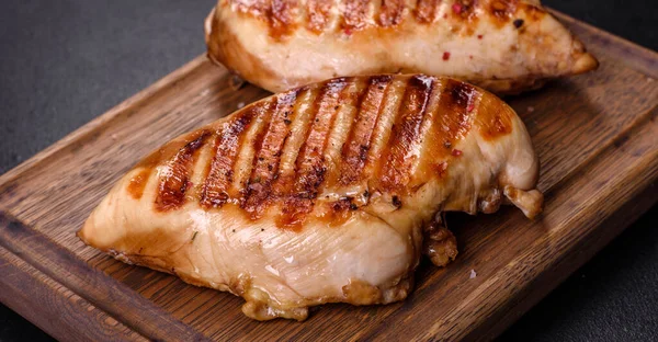 Lezzetli taze ızgara tavuk filetosu, esrarlı baharatlar ve çimento kaplı otlar. Ateşte pişirilmiş bir tabak.