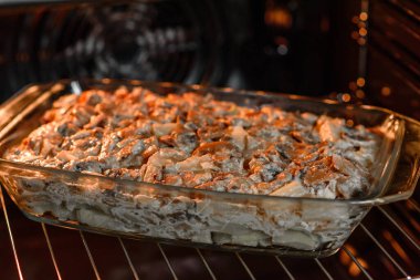 Etli, mantarlı, sebzeli ve patatesli lezzetli bir yemek. Fırında kremalı sosta pişmiş. Ev yemeği pişirmek.