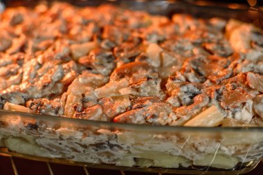 Etli, mantarlı, sebzeli ve patatesli lezzetli bir yemek. Fırında kremalı sosta pişmiş. Ev yemeği pişirmek.