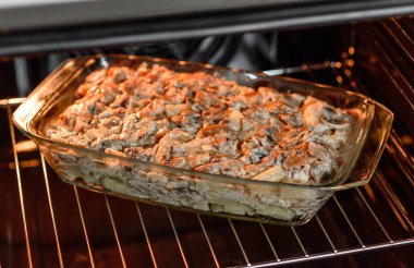 Etli, mantarlı, sebzeli ve patatesli lezzetli bir yemek. Fırında kremalı sosta pişmiş. Ev yemeği pişirmek.