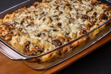 Etli, mantarlı, sebzeli ve patatesli lezzetli bir yemek. Fırında kremalı sosta pişmiş. Ev yemeği pişirmek.