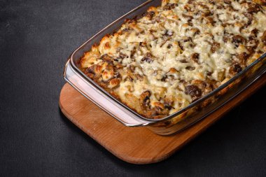 Etli, mantarlı, sebzeli ve patatesli lezzetli bir yemek. Fırında kremalı sosta pişmiş. Ev yemeği pişirmek.