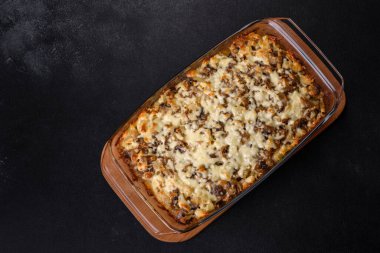 Etli, mantarlı, sebzeli ve patatesli lezzetli bir yemek. Fırında kremalı sosta pişmiş. Ev yemeği pişirmek.