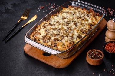 Etli, mantarlı, sebzeli ve patatesli lezzetli bir yemek. Fırında kremalı sosta pişmiş. Ev yemeği pişirmek.