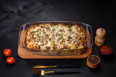 Etli, mantarlı, sebzeli ve patatesli lezzetli bir yemek. Fırında kremalı sosta pişmiş. Ev yemeği pişirmek.