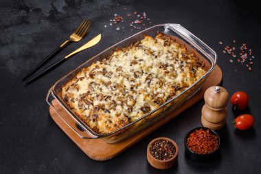 Etli, mantarlı, sebzeli ve patatesli lezzetli bir yemek. Fırında kremalı sosta pişmiş. Ev yemeği pişirmek.