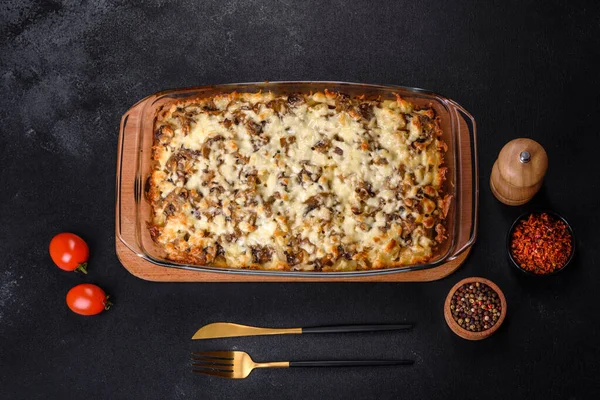 Etli, mantarlı, sebzeli ve patatesli lezzetli bir yemek. Fırında kremalı sosta pişmiş. Ev yemeği pişirmek.