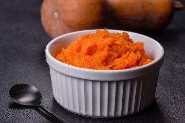 Kabaklı havuçlu bebek püresi, koyu bir arka planda, üst manzara. Taze portakal kabağı sebzeli havuç püresi.