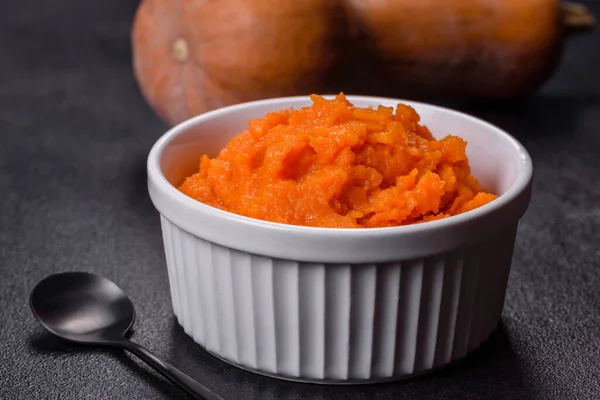 Kabaklı havuçlu bebek püresi, koyu bir arka planda, üst manzara. Taze portakal kabağı sebzeli havuç püresi.