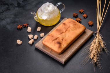 Koyu beton arka planda kuru üzümlü ve çikolatalı fırınlanmış dikdörtgen kek. Ev yapımı lezzetli hamur işleri.