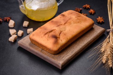 Koyu beton arka planda kuru üzümlü ve çikolatalı fırınlanmış dikdörtgen kek. Ev yapımı lezzetli hamur işleri.