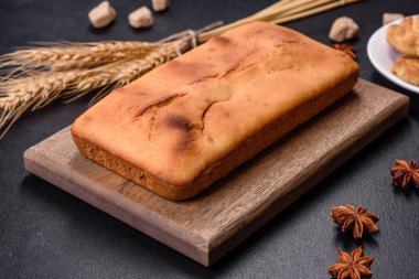 Koyu beton arka planda kuru üzümlü ve çikolatalı fırınlanmış dikdörtgen kek. Ev yapımı lezzetli hamur işleri.