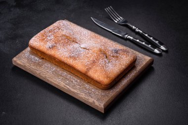 Koyu beton arka planda kuru üzümlü ve çikolatalı fırınlanmış dikdörtgen kek. Ev yapımı lezzetli hamur işleri.