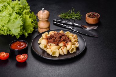 Siyah kasede sığır eti soslu makarna. Koyu arkaplan
