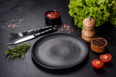 Bıçak ve çatalla arka planda boş gri bir plaka.