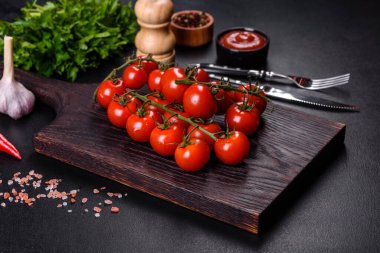 Siyah arka planda baharatlı taze kiraz domatesleri. Gıda arkaplanı