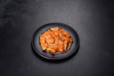 Soslu teriyaki tavuğu, susam, otlar ve baharatlar koyu beton arka planda. Asya mutfağı