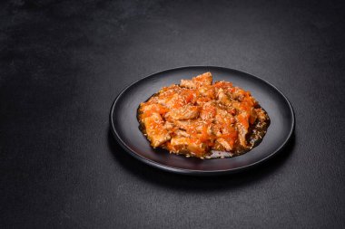 Soslu teriyaki tavuğu, susam, otlar ve baharatlar koyu beton arka planda. Asya mutfağı