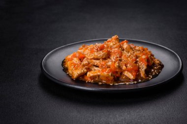 Soslu teriyaki tavuğu, susam, otlar ve baharatlar koyu beton arka planda. Asya mutfağı