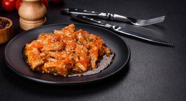 Soslu teriyaki tavuğu, susam, otlar ve baharatlar koyu beton arka planda. Asya mutfağı