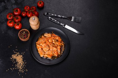 Soslu teriyaki tavuğu, susam, otlar ve baharatlar koyu beton arka planda. Asya mutfağı