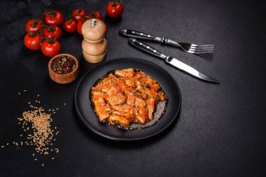 Soslu teriyaki tavuğu, susam, otlar ve baharatlar koyu beton arka planda. Asya mutfağı