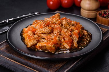 Soslu teriyaki tavuğu, susam, otlar ve baharatlar koyu beton arka planda. Asya mutfağı